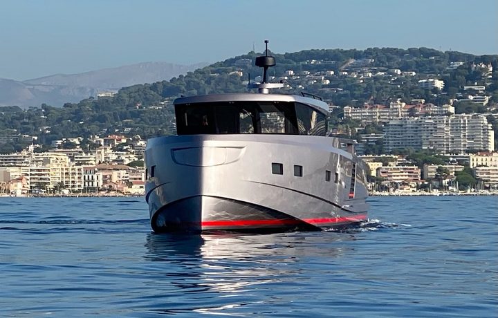 Glacier motor yacht cruising near a coastal town