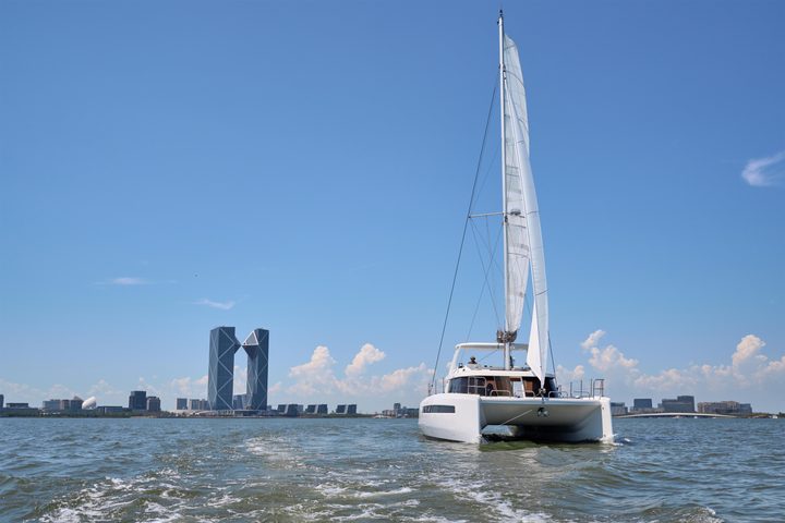 NYX 42C catamaran sailing toward a city skyline